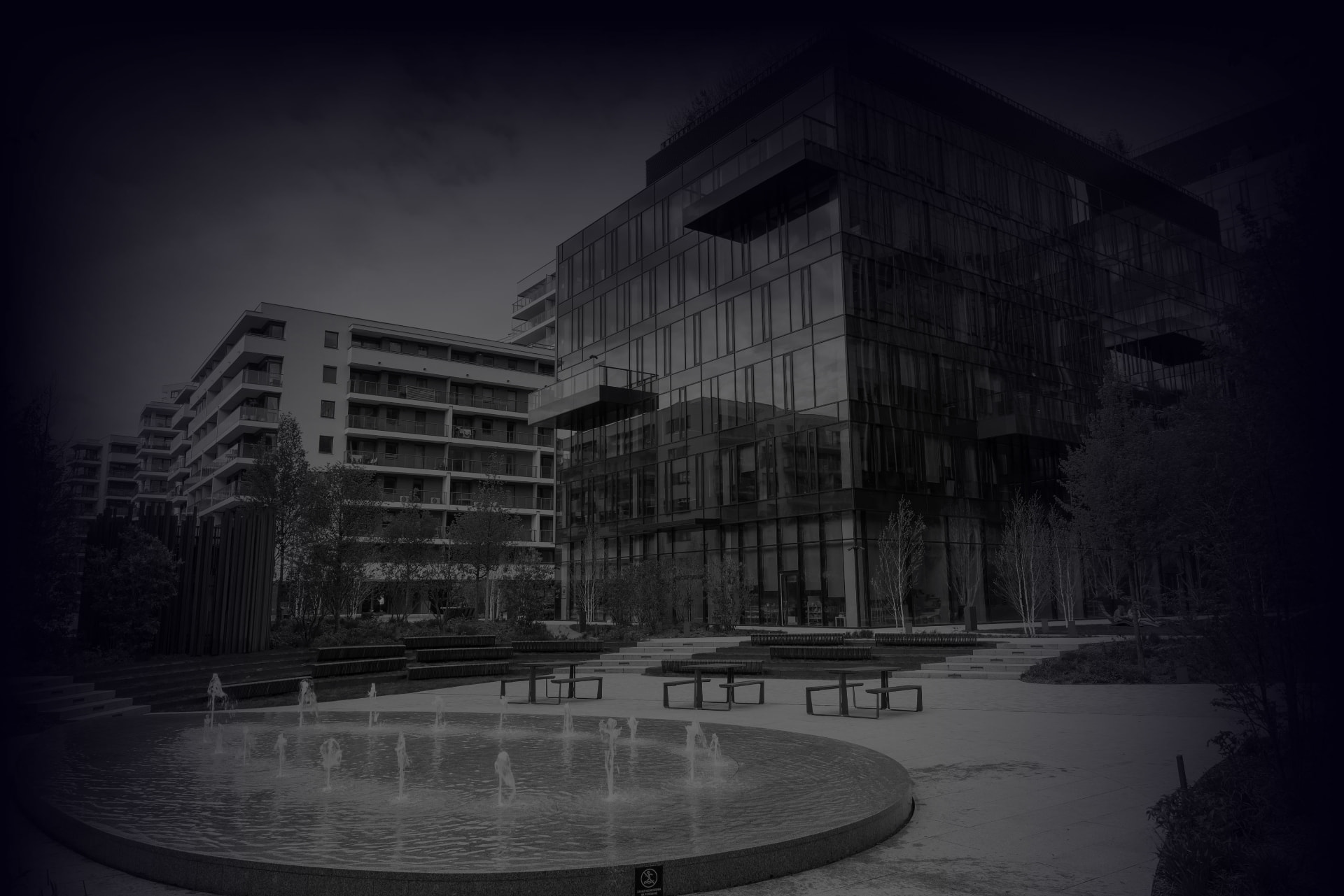 Modern glass office buildings beside a landscaped courtyard